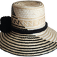 "Colorful handmade Wayuu hat woven from Iraca palm fibers, featuring adjustable fit and culturally significant pompoms."