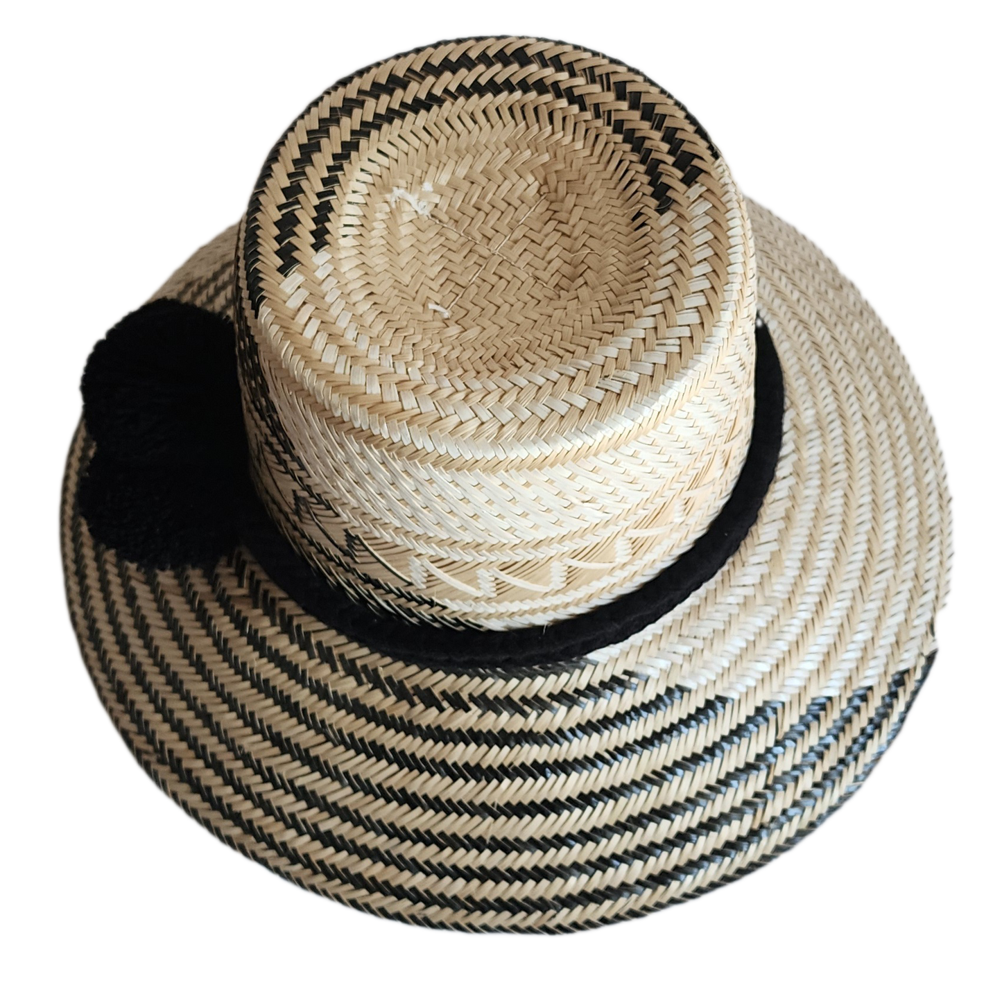 "Colorful handmade Wayuu hat woven from Iraca palm fibers, featuring adjustable fit and culturally significant pompoms."