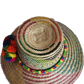 "Colorful handmade Wayuu hat woven from Iraca palm with adjustable fit and cultural pompoms, supporting Wayuu artisans."