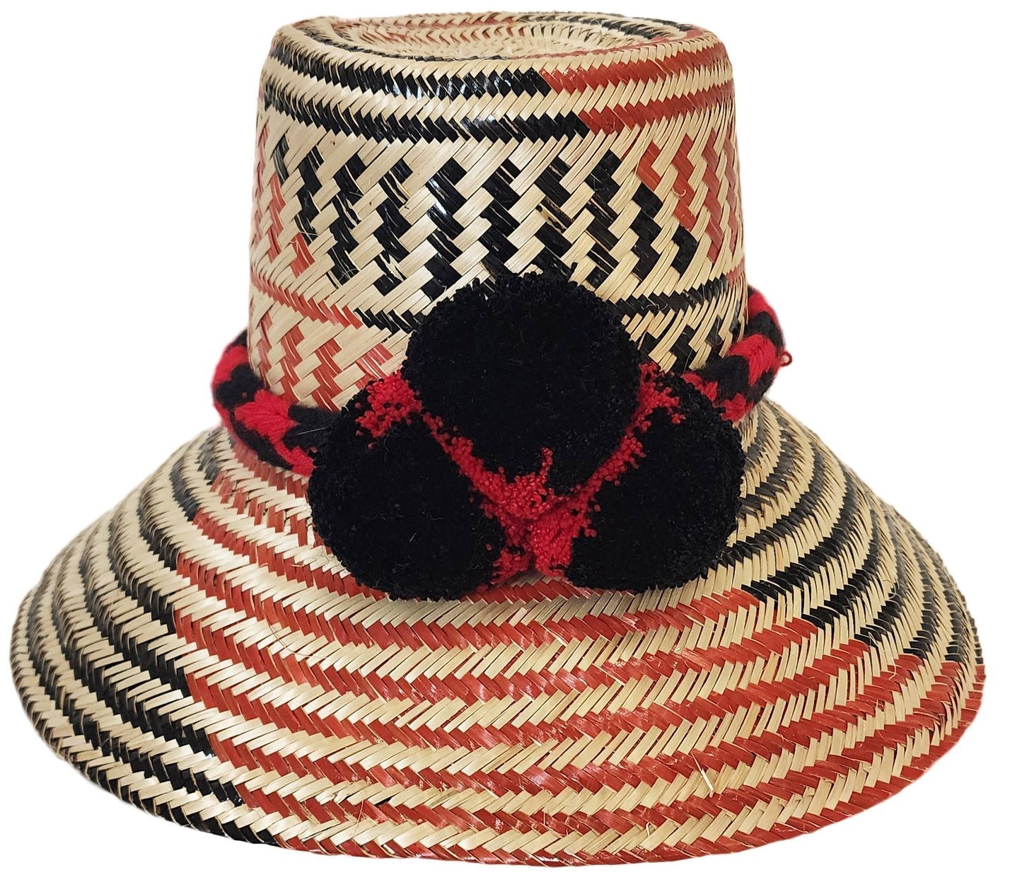"Colorful handmade Wayuu hats from Wuitusu, crafted with Iraca palm fibers, featuring decorative pompoms."