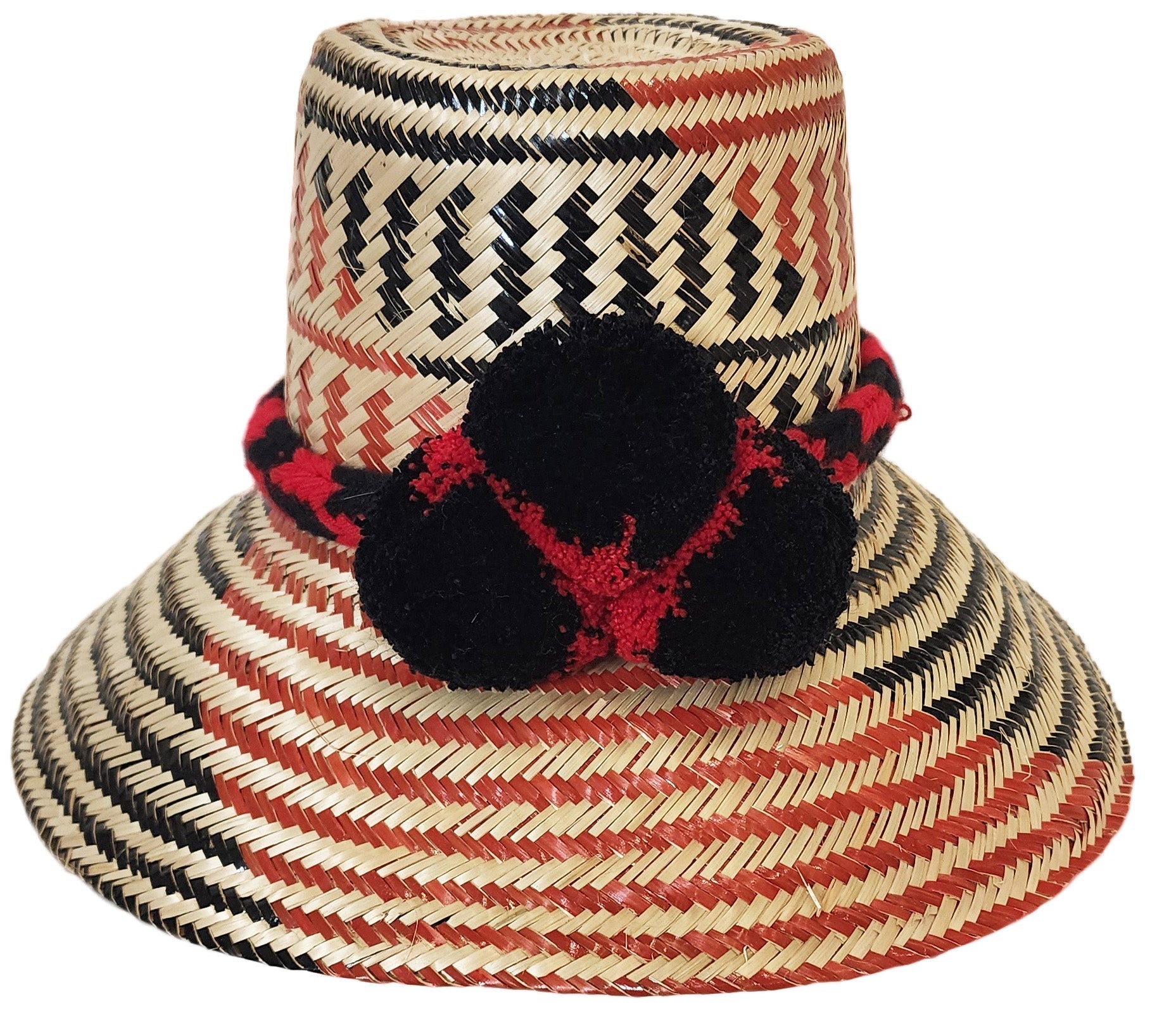 "Colorful handmade Wayuu hats from Wuitusu, crafted with Iraca palm fibers, featuring decorative pompoms."