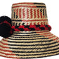 "Colorful handmade Wayuu hats from Wuitusu, crafted with Iraca palm fibers, featuring decorative pompoms."