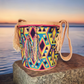 "Colorful handmade Wuitusu crochet Wayuu bag, showcasing traditional geometric patterns and a long woven strap for versatile 