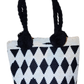 "Colorful handmade Wuitusu Wayuu crochet bag with short handle, celebrating traditional artistry and supporting fair trade."