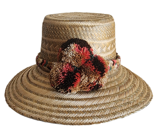 "Colorful handmade Wuitusu Wayuu hat crafted from Iraca palm fibers, adorned with culturally significant pompoms."