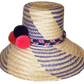"Colorful handmade Wuitusu Wayuu hat crafted from Iraca palm fiber, adorned with culturally significant pompoms, adjustable f