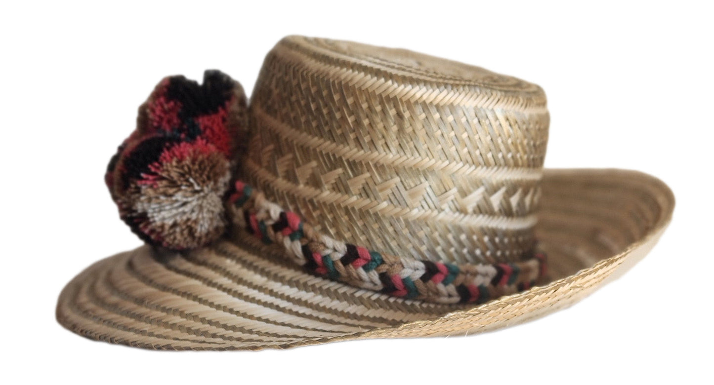 "Colorful handmade Wuitusu Wayuu hat crafted from Iraca palm fibers, adorned with culturally significant pompoms."