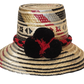 "Colorful, handwoven Wayuu hat from Wuitusu, adorned with culturally significant pompoms, offering flexible styling and sun p