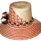"Colorful handwoven Wayuu hat made from Iraca palm fibers, adorned with cultural pompoms, offering versatile and stylish sun 