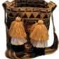 Large bohemian crochet bag, handmade by Wayuu artisans, featuring black and gold patterns, crossbody strap, and multicolor tassel accents.