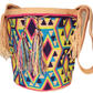 Vibrant bohemian crochet bag, handmade by Wayuu artisans, featuring multicolor geometric weave, tan edges, crossbody strap, and tassels.