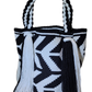 Bohemian crochet handbag, handmade by Wayuu artisans, featuring black-and-white geometric zigzag design, thick braided handles, and long tassels.