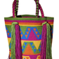 Bohemian crochet handbag, handmade by Wayuu artisans, featuring rainbow waterfall-inspired design, chunky braided handles, and large tassels.