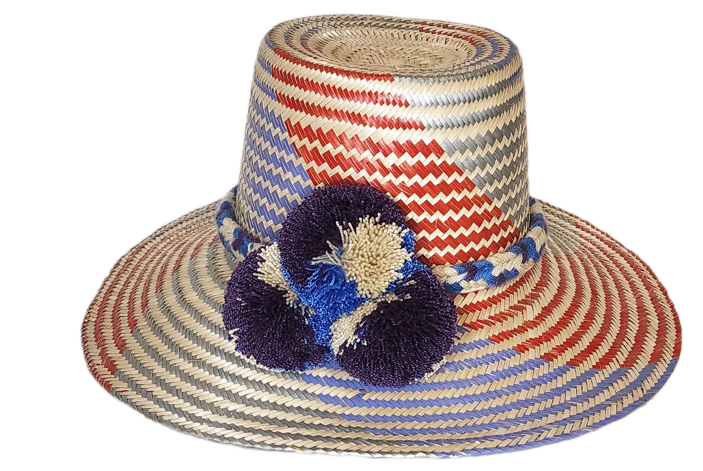 "Colorful Wuitusu Wayuu hat crafted from Iraca palm fibers, adorned with significant pompoms, versatile and adjustable fit."