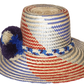"Colorful Wuitusu Wayuu hat crafted from Iraca palm fibers, adorned with significant pompoms, versatile and adjustable fit."