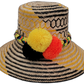 Daniela handmade Wayuu straw hat with yellow and black palm weave and vibrant pompoms

