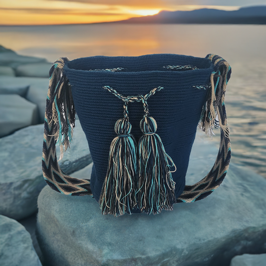Dark blue handmade Wayuu crochet bag with turquoise tassels and a Boho chevron strap — artisan and bold.