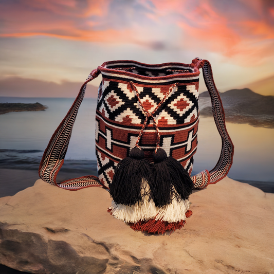 Handmade Wayuu crochet bag with earth-tone diamond patterns and tassels.