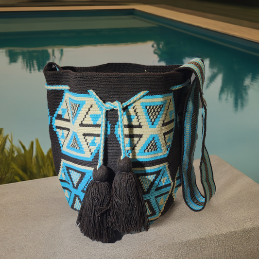 Handmade Wayuu crochet bag with turquoise and cream triangle patterns.