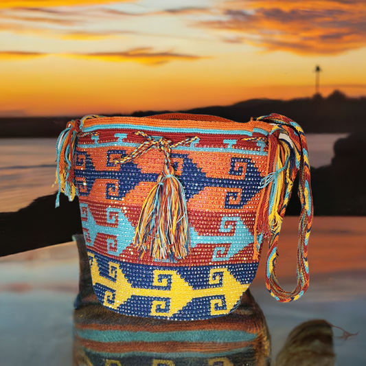 Handmade Wayuu crochet bag in vibrant orange, blue, and yellow geometric design.