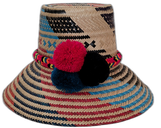 Gracie handmade Wayuu straw hat with bold black, blue, and red woven patterns and matching pompoms.

