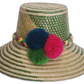 Handmade Wayuu straw hat with green woven pattern and bold fuchsia, navy blue, and green pompoms.Bohemian Wayuu hat featuring green body and vibrant handmade pompoms

