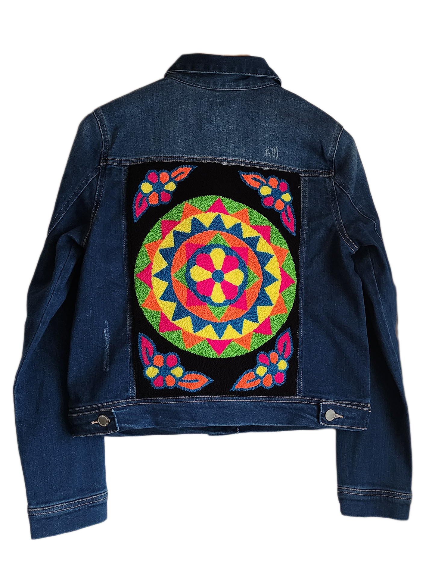 "Handcrafted denim jacket with vibrant, Wayuu-inspired punch needle embroidery on the back, showcasing artisanal craftsmanshi