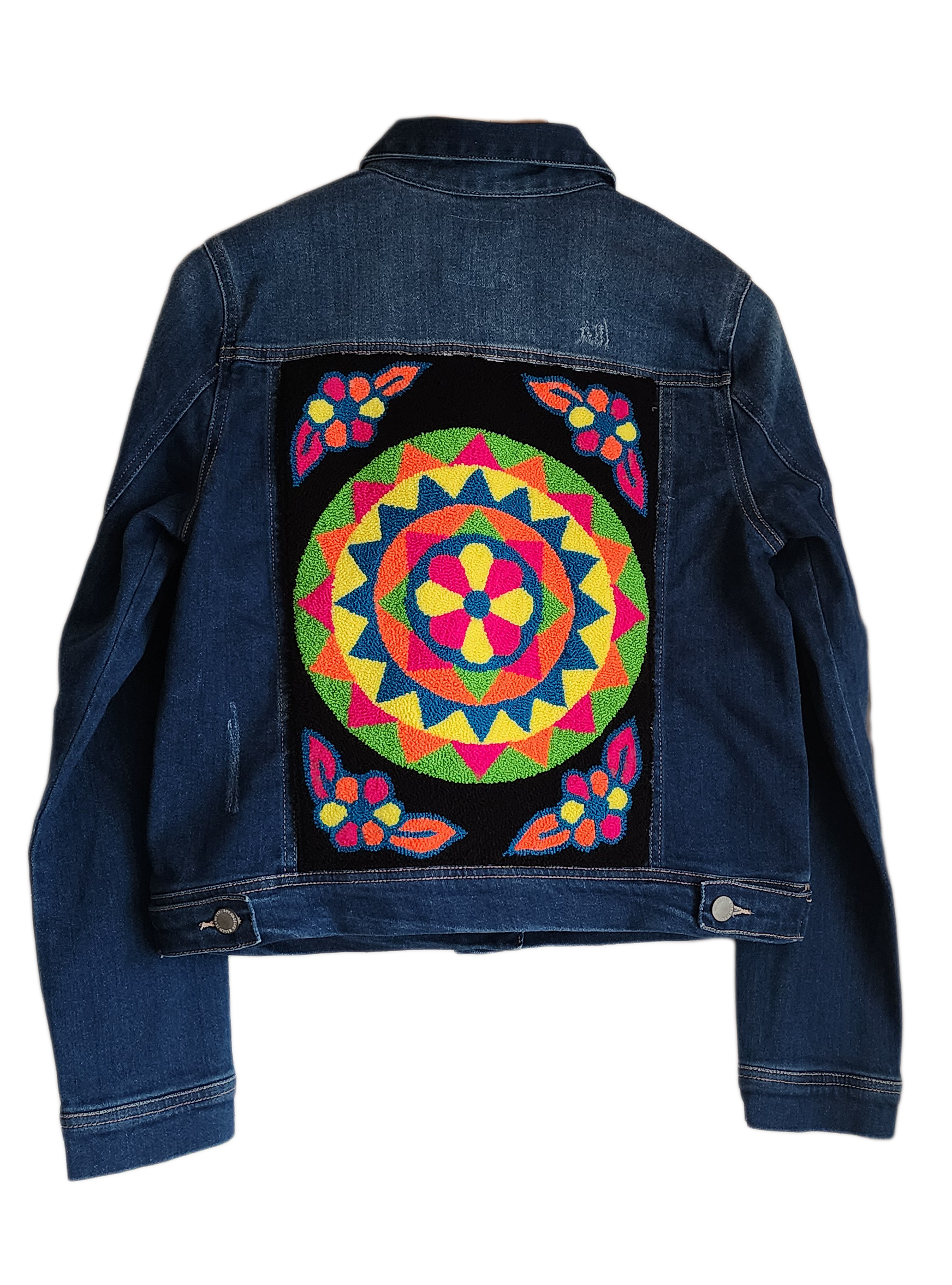 "Handcrafted denim jacket with vibrant, Wayuu-inspired punch needle embroidery on the back, showcasing artisanal craftsmanshi