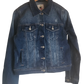 "Handcrafted denim jacket with vibrant, Wayuu-inspired punch needle embroidery on the back, showcasing artisanal craftsmanshi