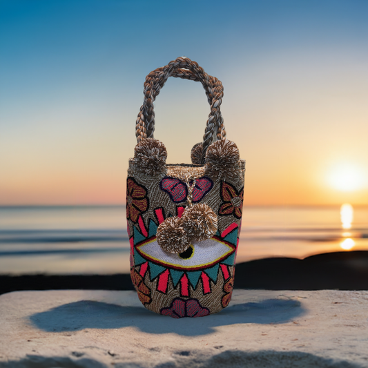 "Handcrafted Wuitusu punch needle bag with vibrant, textured designs by Wayuu artisans, featuring a short handle and durable 