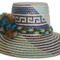 Colorful Wayuu hat in green and blue tones with woven crown and soft pompom details