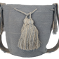 Neutral gray Wayuu bag crafted in crochet by artisans, finished with soft tassels — perfect for a clean, Bohemian look.
