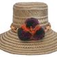 Handwoven Wayuu straw hat with yellow braided band and multicolor pom-poms — boho chic sun hat for summer style.