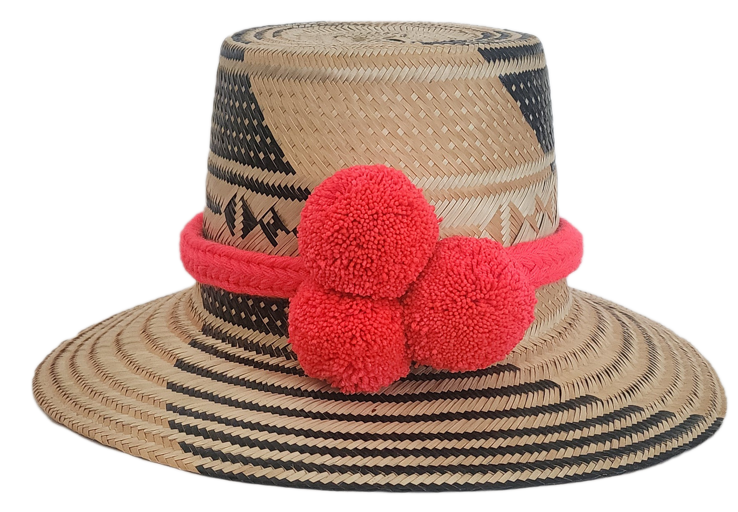 Wayuu straw hat with black geometric weave and bright red pom-poms — handmade boho accessory.