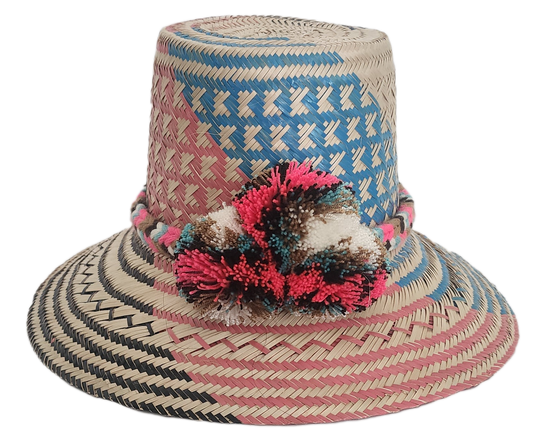 Colorful Wayuu straw hat featuring woven blue, pink, and natural patterns with a bright multicolor pom-pom band. A bold, handcrafted boho fashion piece.