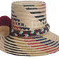 Handwoven Wayuu straw hat with red, navy, and golden zigzag patterns and a braided band finished with tri-color pom-poms. A bold, artisan-crafted boho hat.