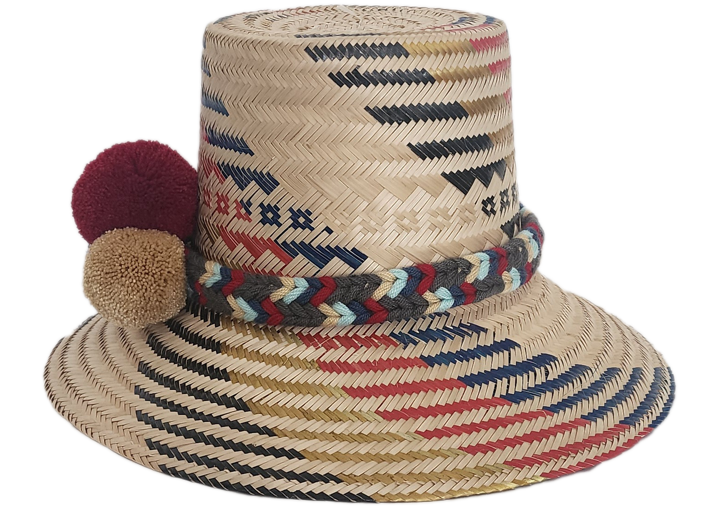 Handwoven Wayuu straw hat with red, navy, and golden zigzag patterns and a braided band finished with tri-color pom-poms. A bold, artisan-crafted boho hat.