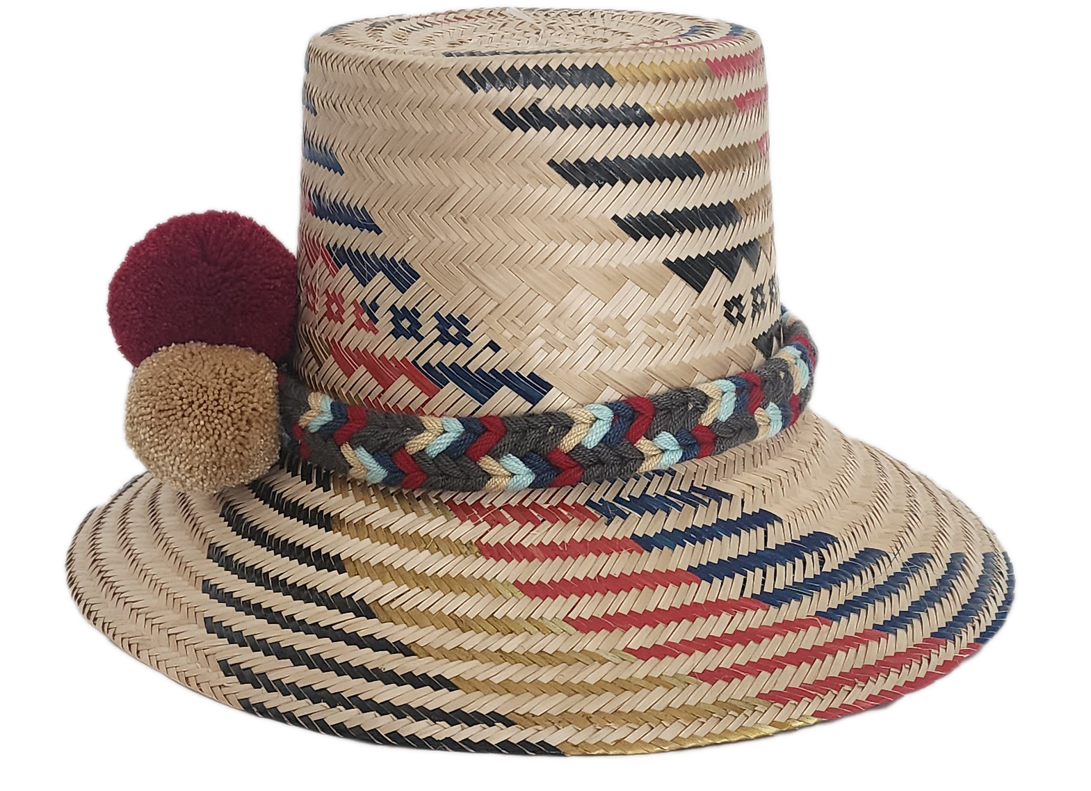 Handwoven Wayuu straw hat with red, navy, and golden zigzag patterns and a braided band finished with tri-color pom-poms. A bold, artisan-crafted boho hat.