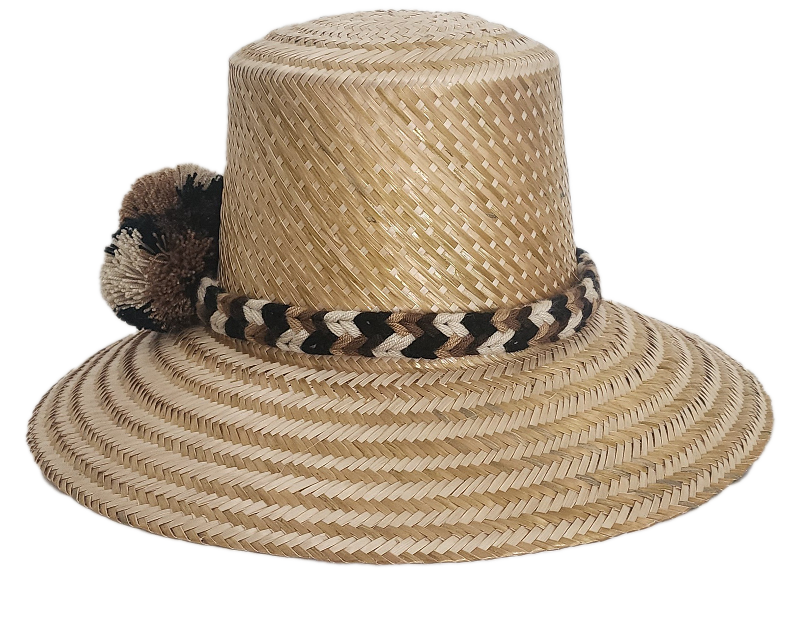 Handwoven Wayuu straw hat in a natural finish, featuring a braided band with earth-toned pom-poms in black, beige, and brown. A timeless boho accessory.