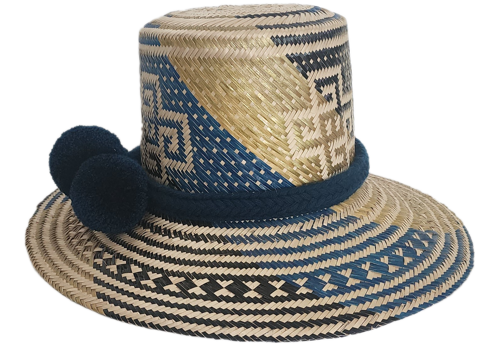 Artisan Wayuu straw hat with bold blue and cream geometric weaving, wide brim, and navy pom-pom band. A handcrafted boho accessory for standout summer style.