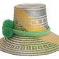 Handwoven Wayuu straw hat with green, yellow, and gray tribal patterns, wide brim, and bright green pom-pom band. A bold, bohemian summer accessory.