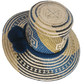 Artisan Wayuu straw hat with bold blue and cream geometric weaving, wide brim, and navy pom-pom band. A handcrafted boho accessory for standout summer style.