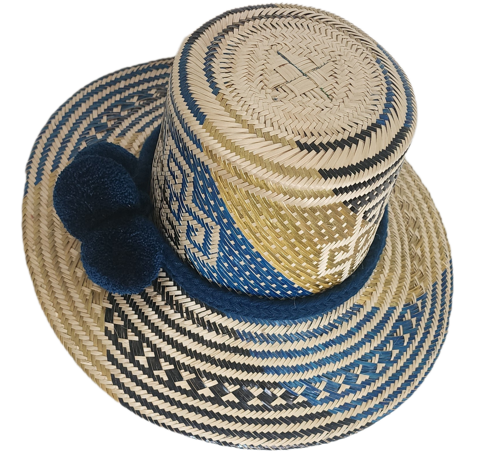 Artisan Wayuu straw hat with bold blue and cream geometric weaving, wide brim, and navy pom-pom band. A handcrafted boho accessory for standout summer style.