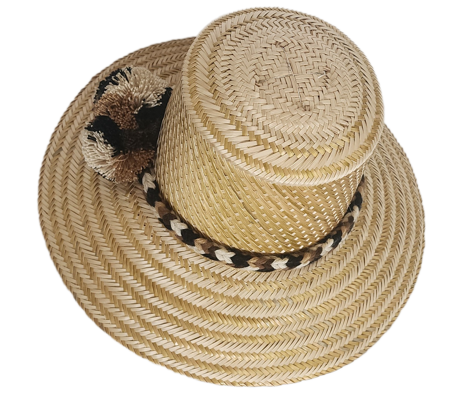 Handwoven Wayuu straw hat in a natural finish, featuring a braided band with earth-toned pom-poms in black, beige, and brown. A timeless boho accessory.