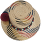 Handwoven Wayuu straw hat with red, navy, and golden zigzag patterns and a braided band finished with tri-color pom-poms. A bold, artisan-crafted boho hat.