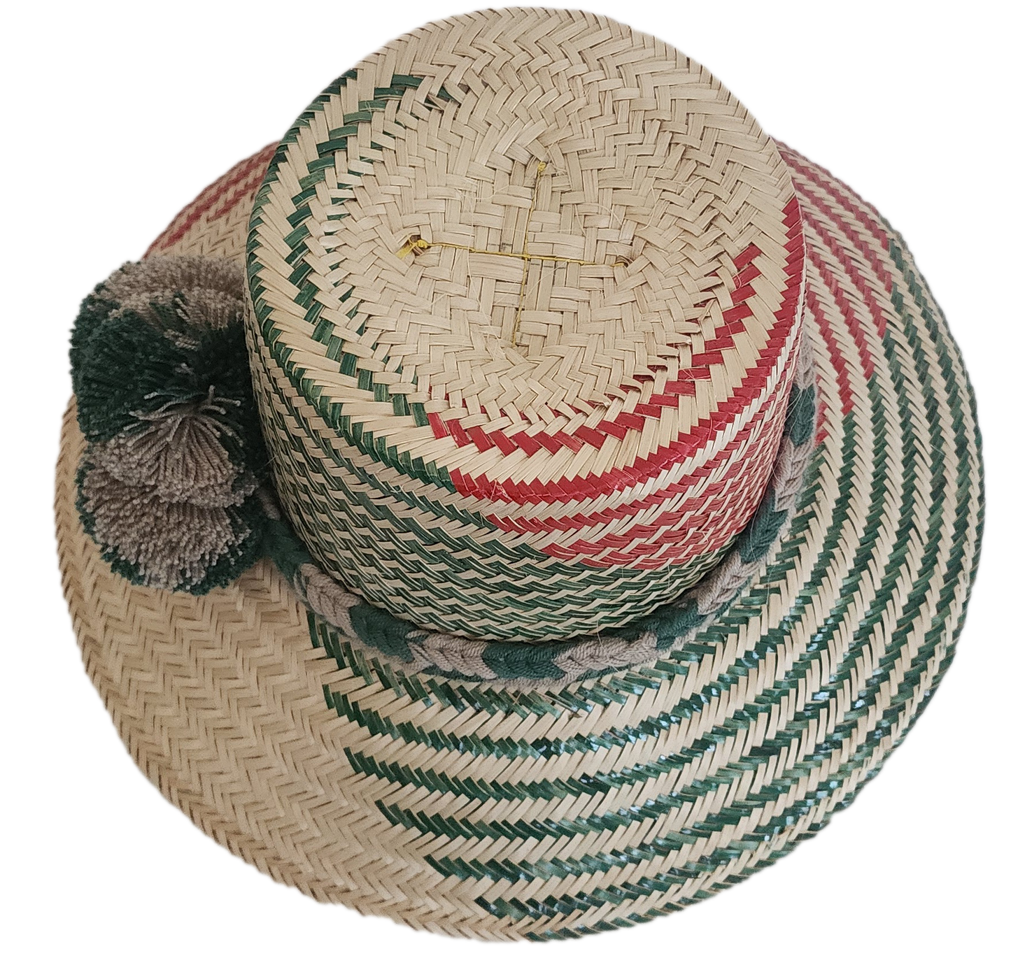 Handcrafted Wayuu straw hat with natural green-red chevron weave and neutral-toned pom-poms.