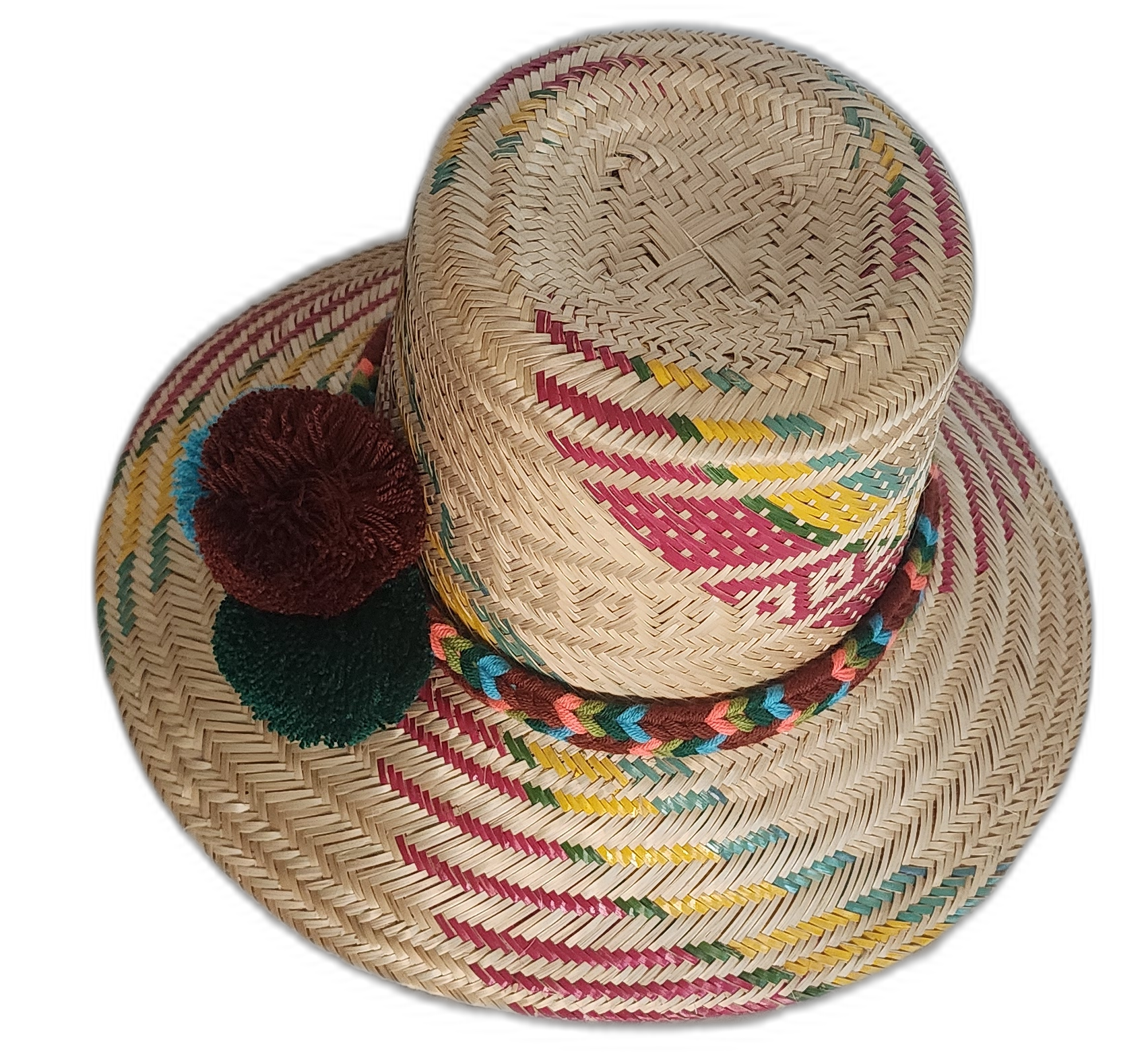 Bohemian straw hat crafted by Wayuu artisans with earth-toned patterns and artisan pompoms.