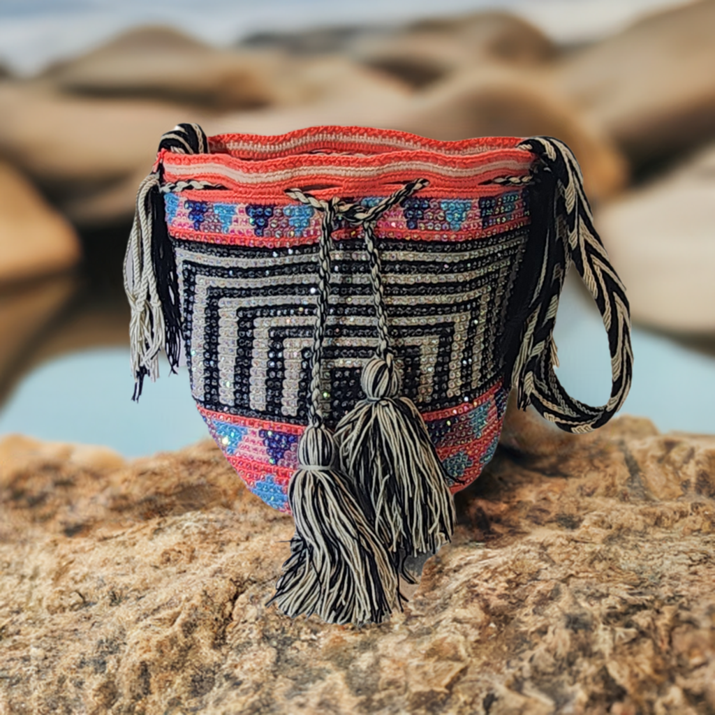 "Handmade colorful Wayuu crochet bag with intricate patterns and adjustable straps, showcasing sustainable and ethical fashio