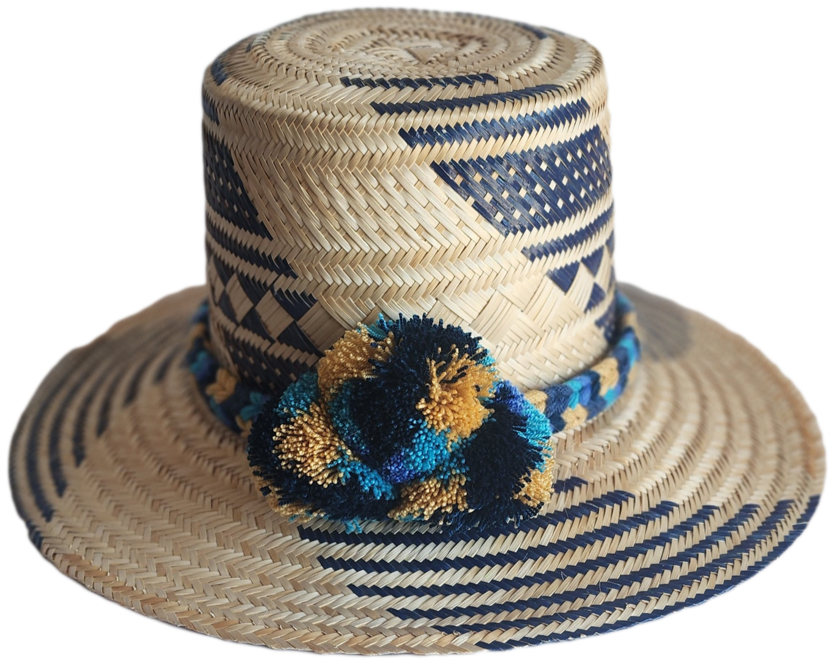 "Handmade, colorful Wayuu hat crafted from Iraca palm, adorned with meaningful pompoms, demonstrating artisan craftsmanship."