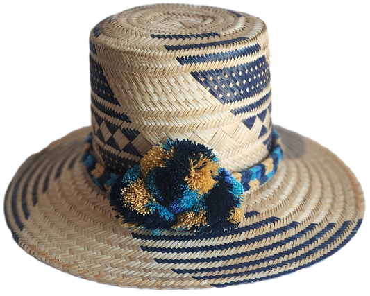 "Handmade, colorful Wayuu hat crafted from Iraca palm, adorned with meaningful pompoms, demonstrating artisan craftsmanship."